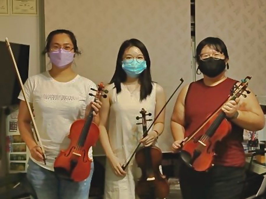 Adult students with their violins after a group class